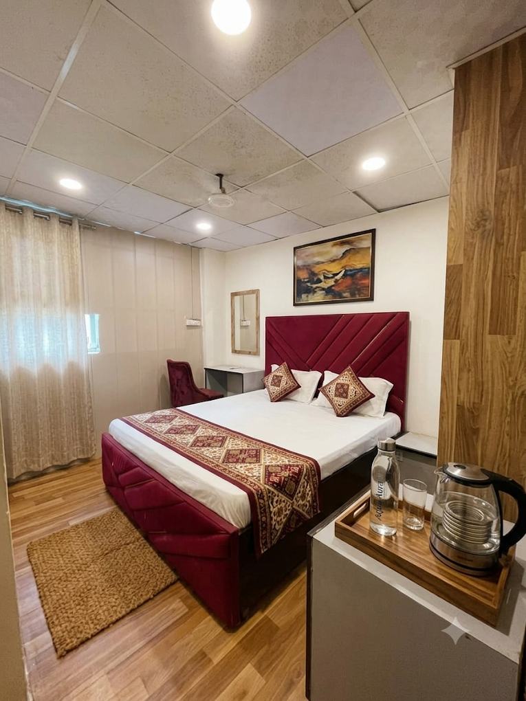 Guest room at Rudra Residency with a deep red headboard and sheer curtains