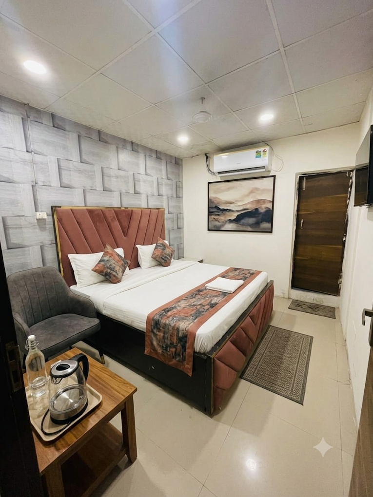 Guest room at Rudra Residency with a rust-toned headboard and wall-mounted TV